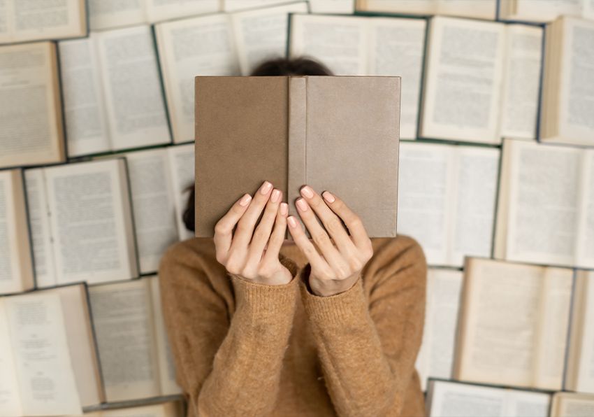 Imatge del esdeveniment:Dona amb un llibre front al seu rostre